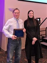 Bob holding his award plaque next to NSPE-AK Fairbanks Chapter President Emily Winfield